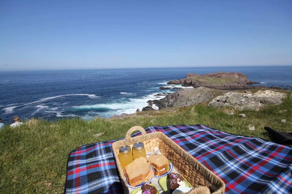 Photo of picnic and a tartan blanket with ocean in background