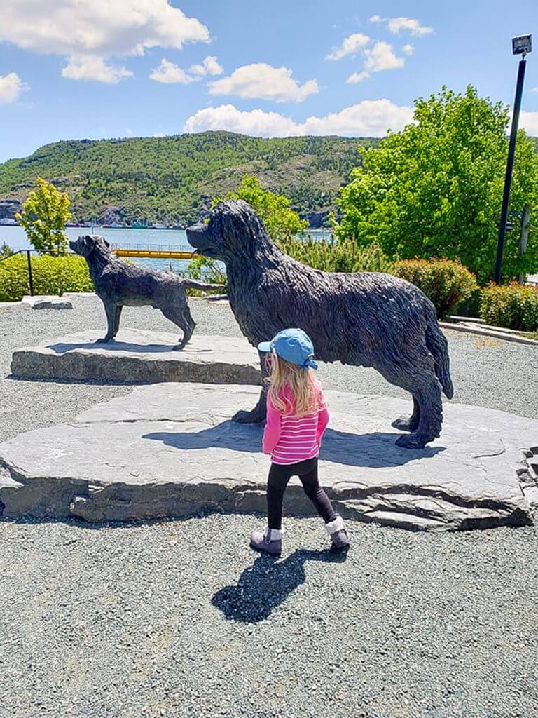 Blake walking through harbour side park right next to the two Newfoundland dogs. It's a beautiful sunny day.