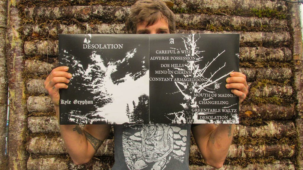 You can barely see Kyle peeking out from behind his album, Desolation. He's holding it up in front of him.