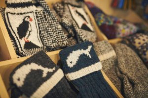 Rack of knitted crafts including sock and mittens with puffins and whales and hearts
