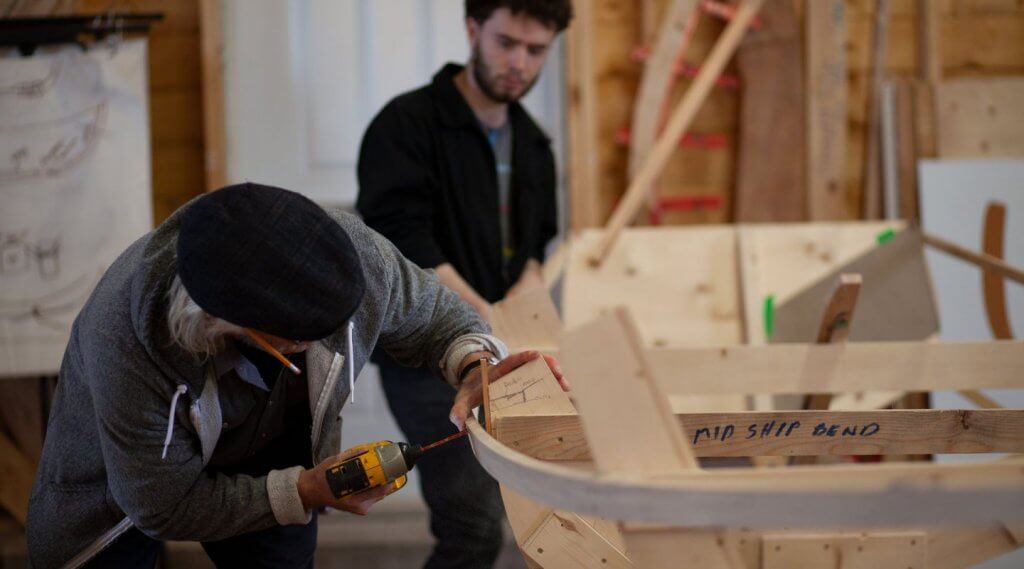 Two men build a wooden boat at the Wooden Boat Museum in Winterton, Newfoundland & Labrador