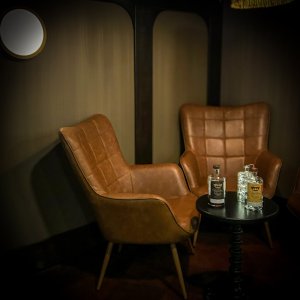 Cosy chairs and table for two at Wooden Walls Distilling